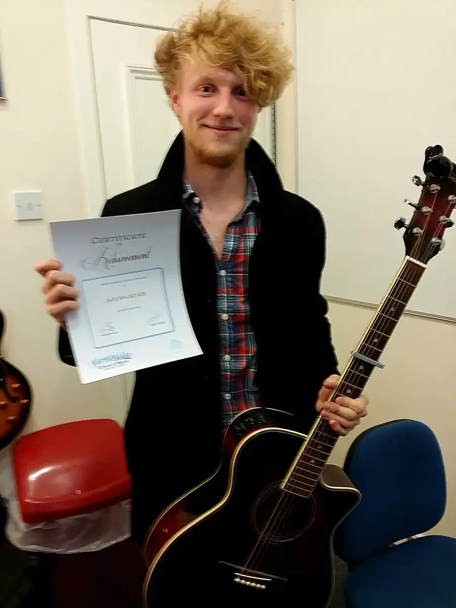 Guitar student Jack Mackenzie holding his certificate of achievement at Morningside School of Music Guitar student Jack Mackenzie holding his certificate of achievement at Morningside School of Music